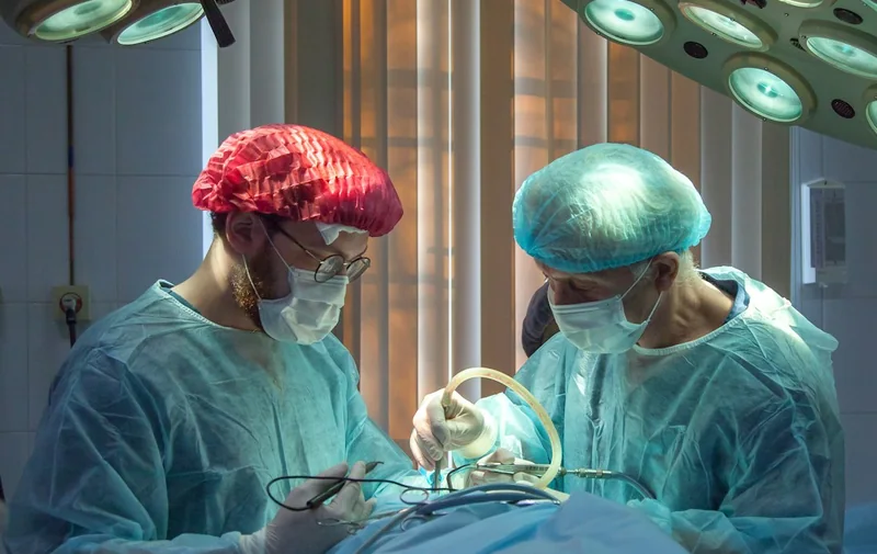 Surgeons performing an operation under theatre lights