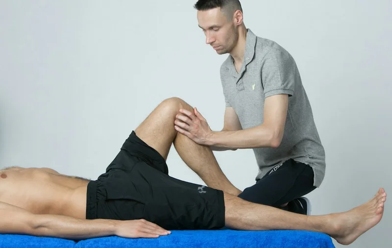 Specialist examining a patient's knee
